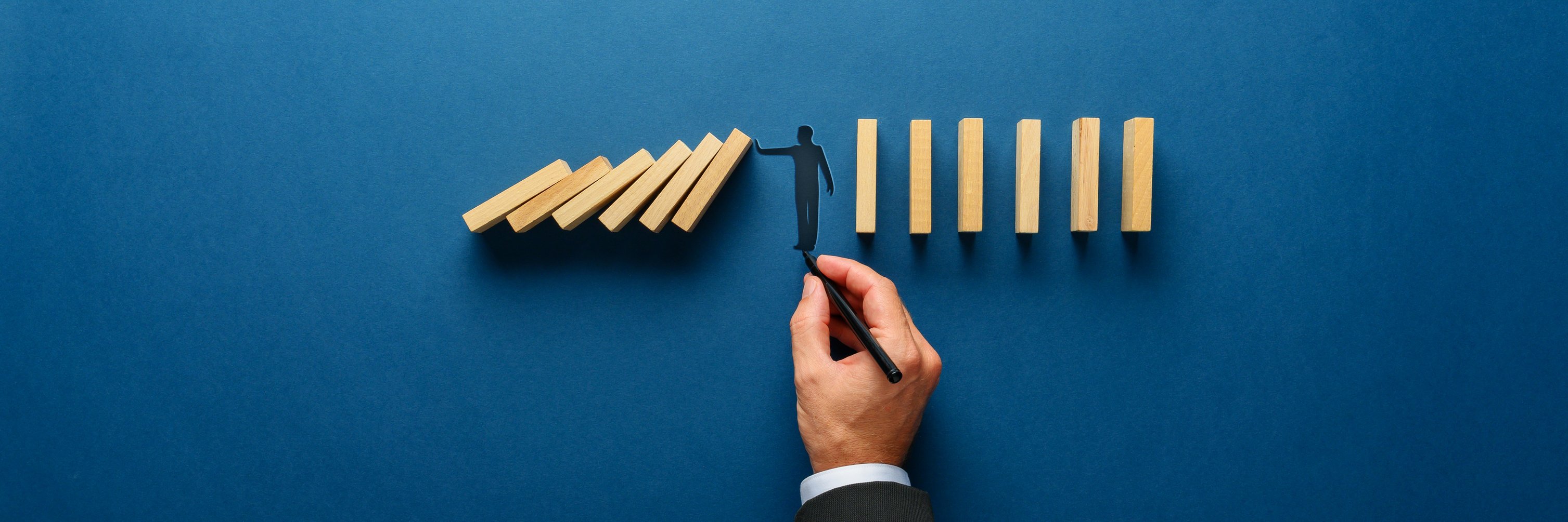 Silhouette of a Man Making a Stop Gesture to Prevent Wooden Domi